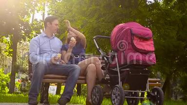 爸爸和妈妈吃冰淇淋，和婴儿车一起在公园散步，暑假全家放假